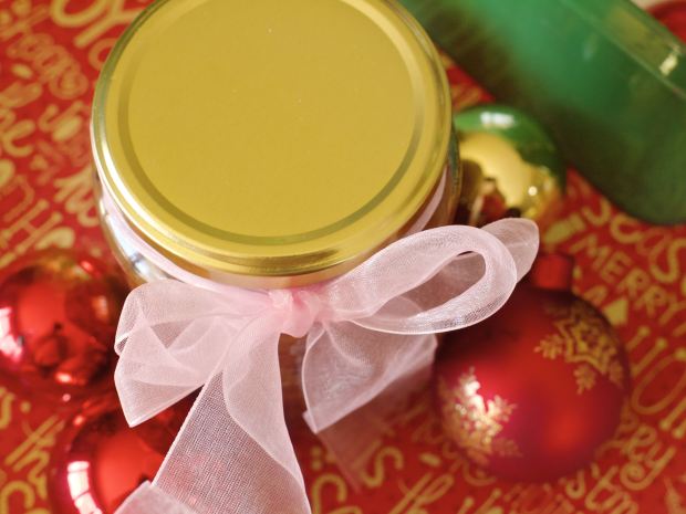 A jar with a ribbon around it surrounded by baubles.