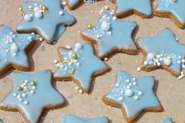 Blue-iced star cookies on a baking tray
