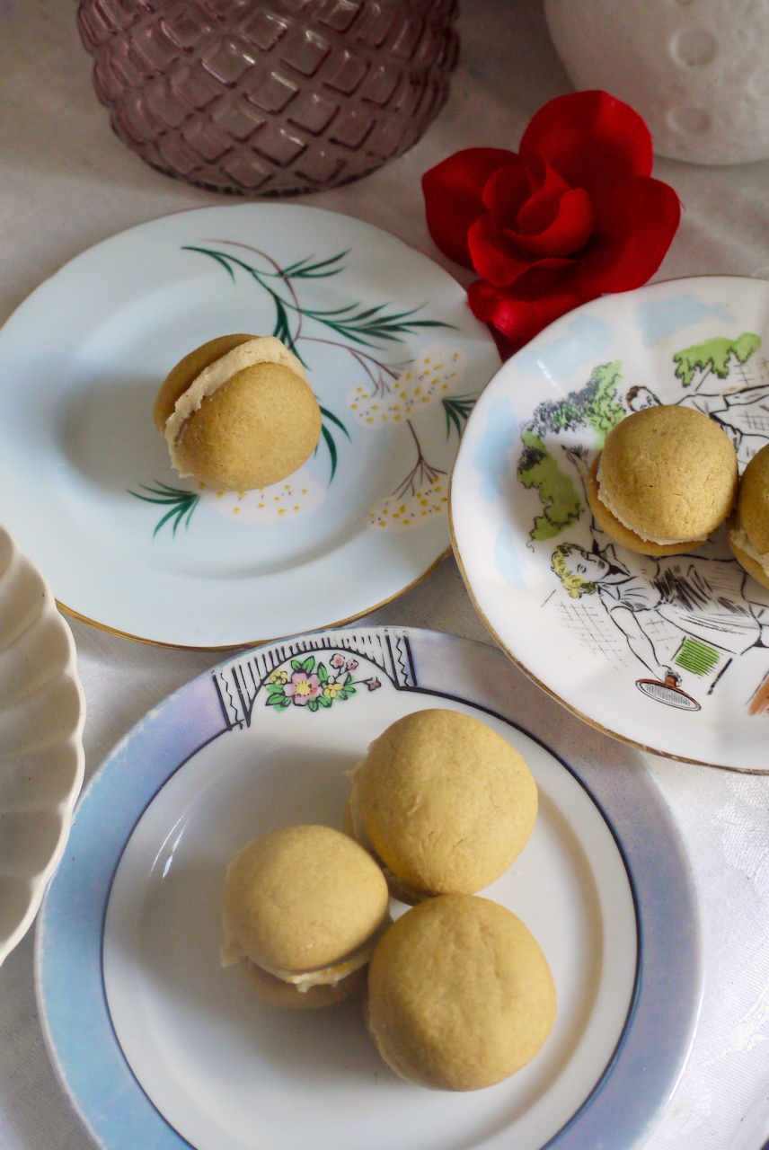 ginger cookies on a selection of small plates with a red fabric rose