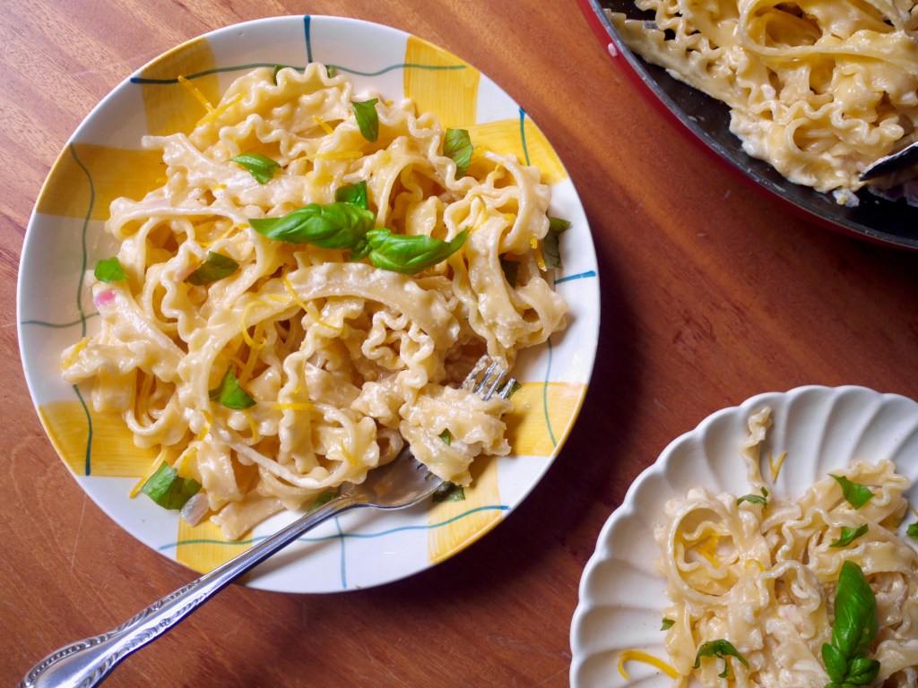 Two plates of pasta, one white, one yellow and white. This image links through to a web page with the recipe.