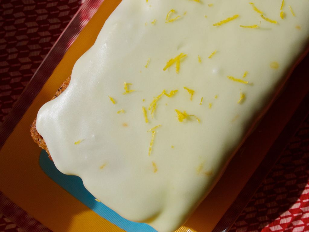 An iced loaf cake on an orange plate. This image links through to a web page with the recipe.