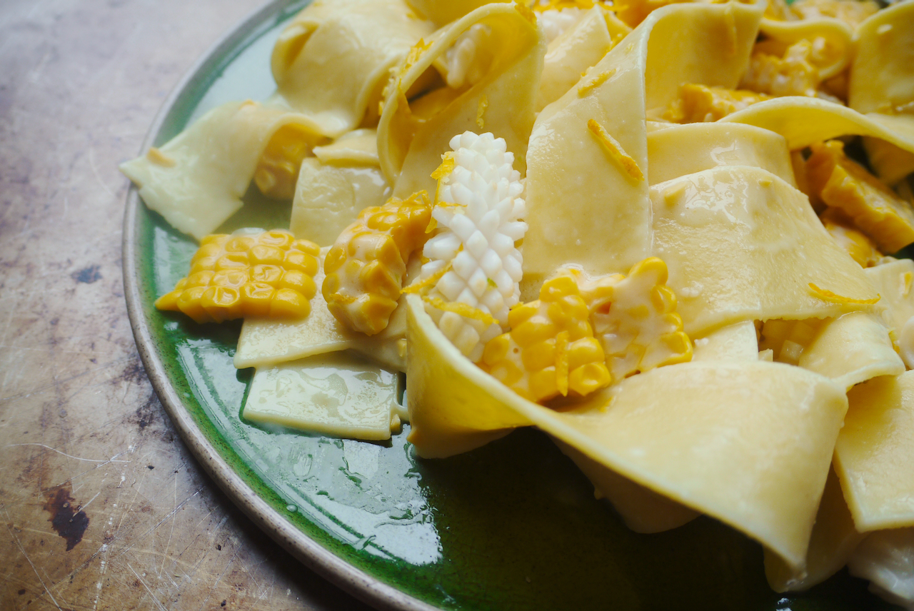 pappardelle corn and squid on a green plate