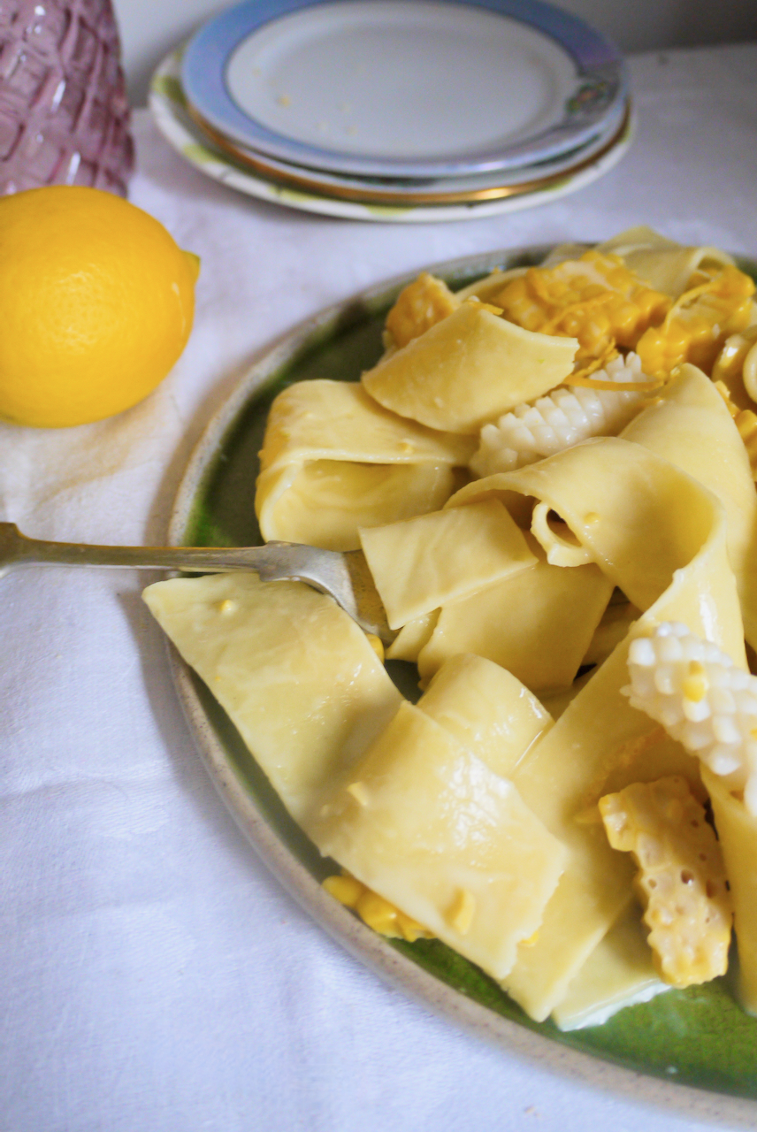 pappardelle with lemon in the background on a white tablecloth