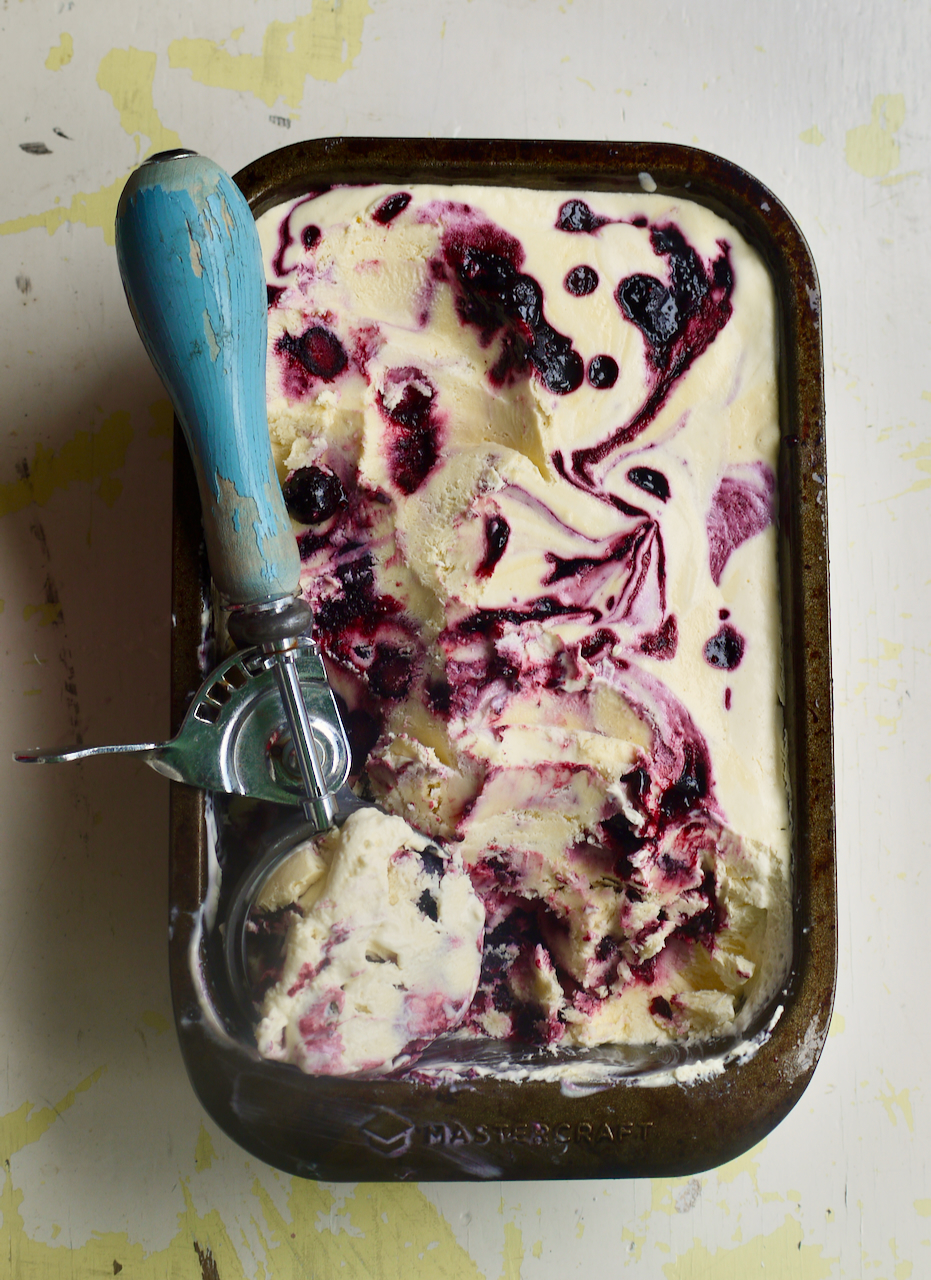 a loaf tin of blueberry ice cream with a blue ice cream scoop resting on top