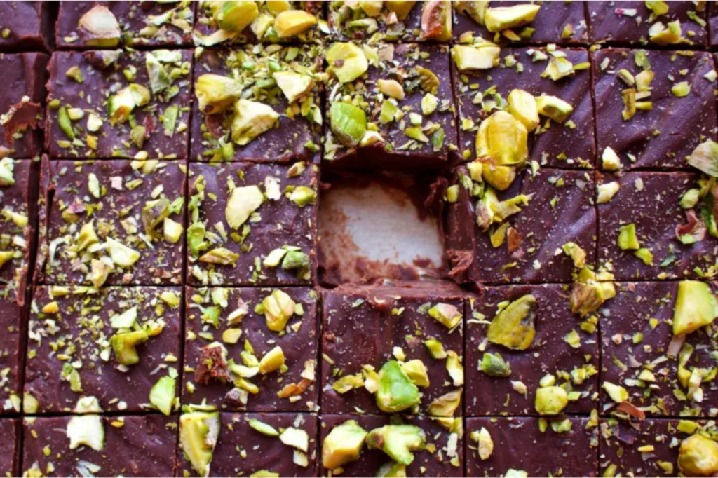 Chocolate pistachio fudge with one piece missing. This image links through to a web page with this recipe.