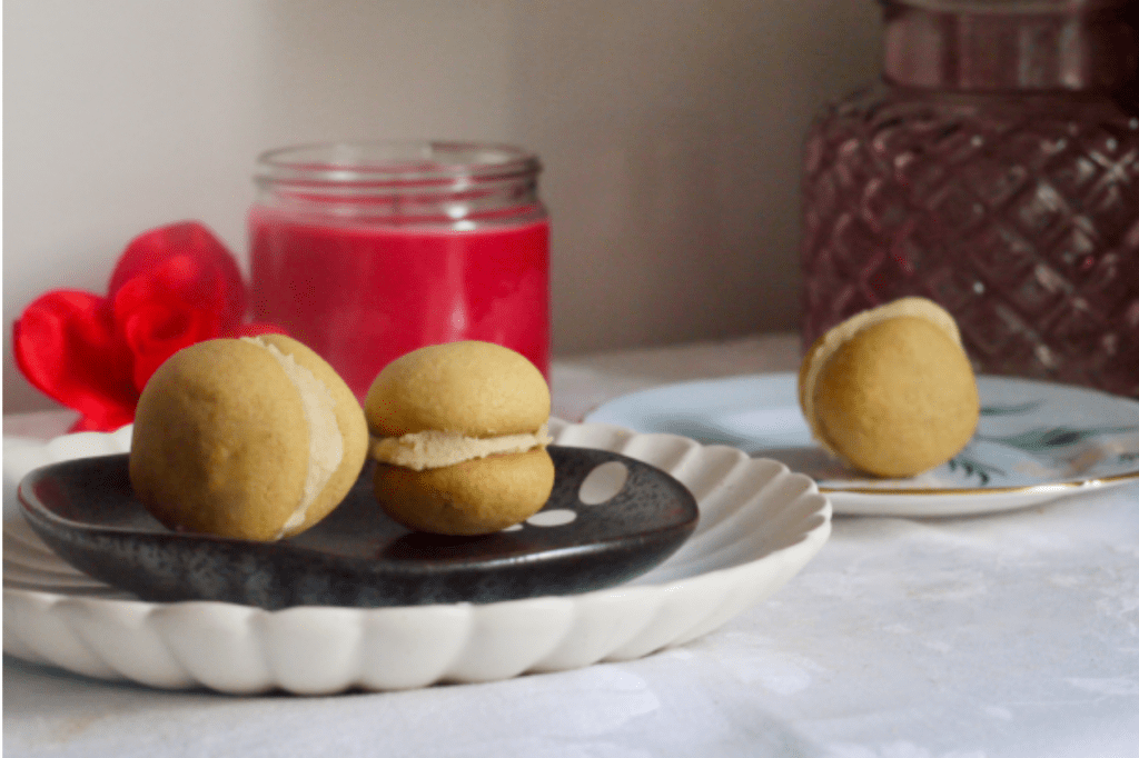 Ginger kisses on a plate in front of a red candle. This image links through to a web page with the recipe.