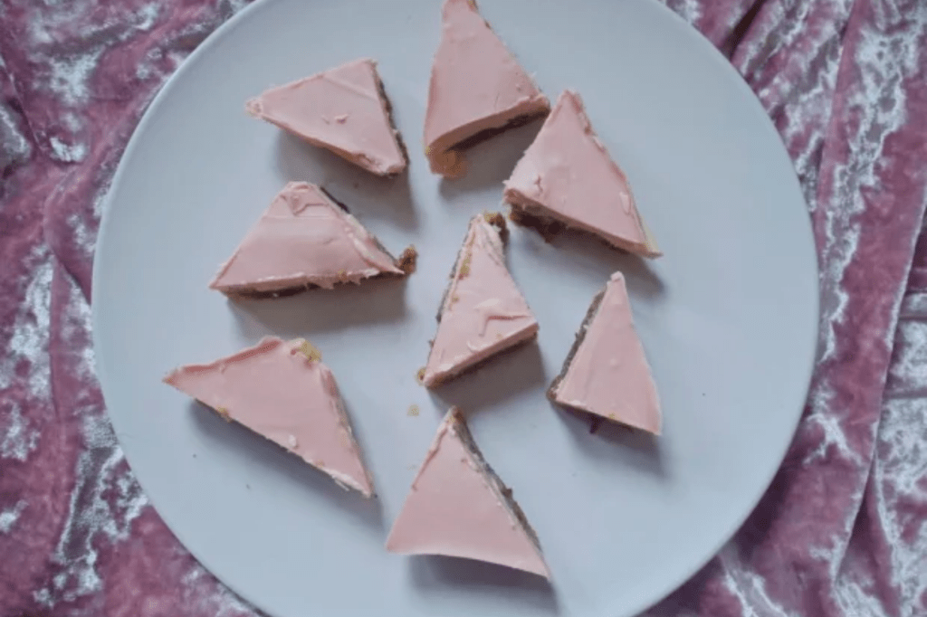 Triangle slices of pink toffee on a pink plate. This image links through to a web page with this recipe.