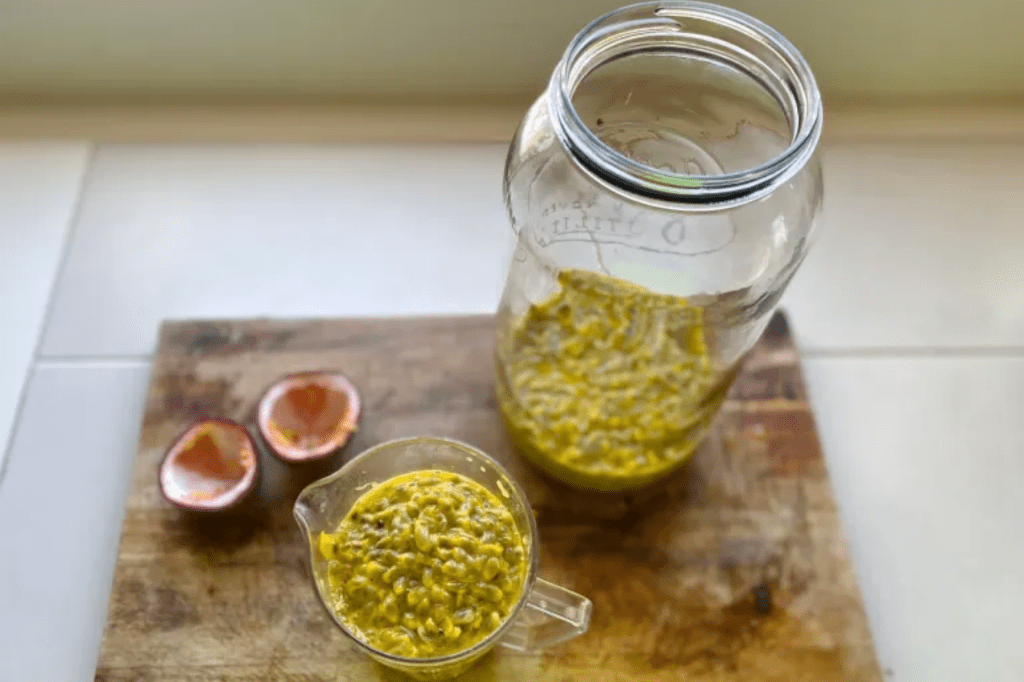 A glass jar and a measuring jug full of passionfruit pulp. This image links through to a web page with this recipe.