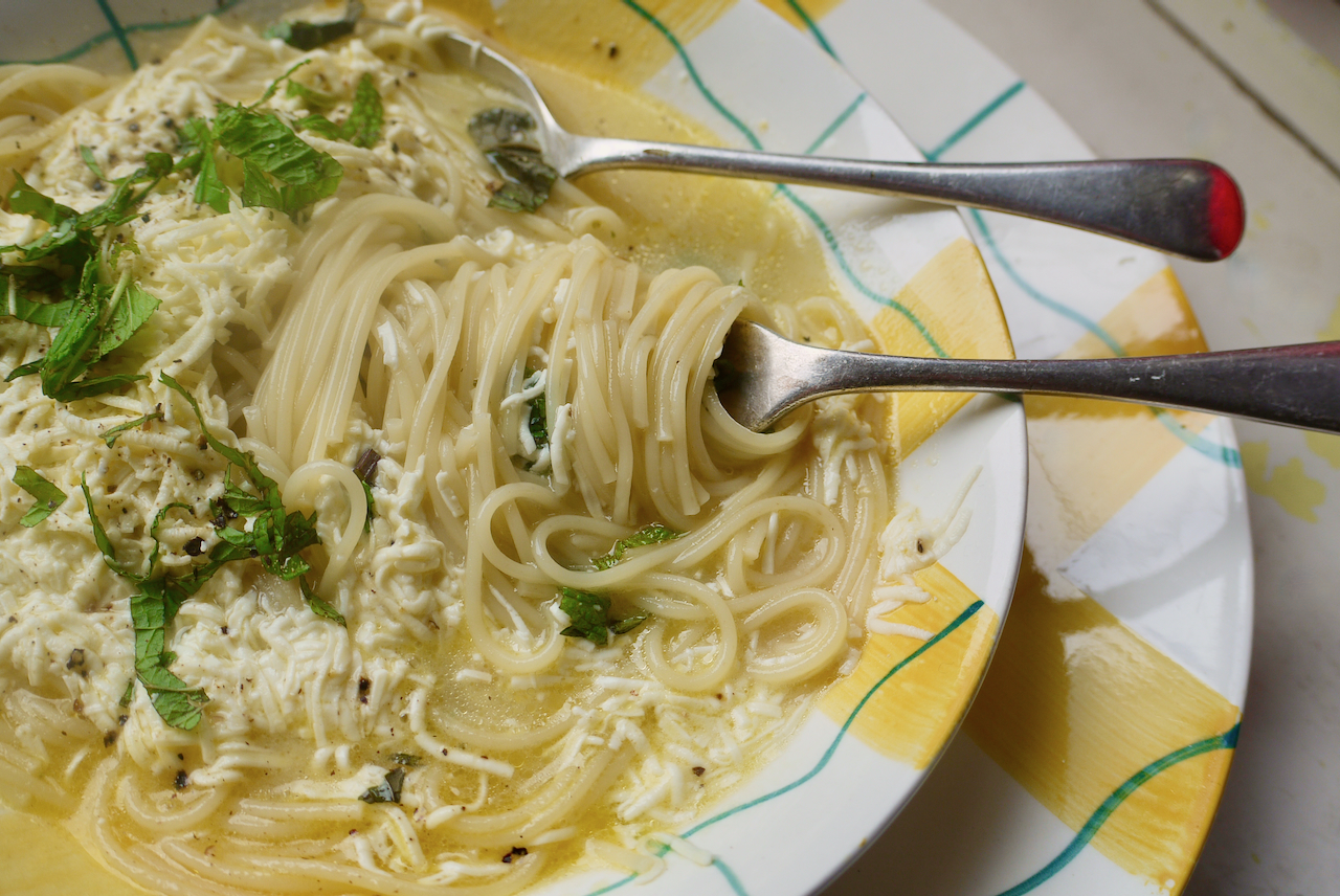 Pasta twirled around a fork in a bowl of soup