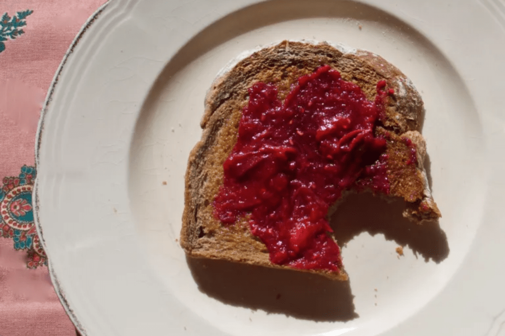 A piece of toast spread with jam on a white plate. This image links through to a web page with the recipe.