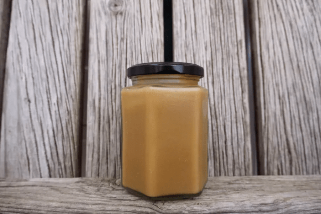 A jar of caramel sauce on a wooden background. This image links through to a web page with the recipe.