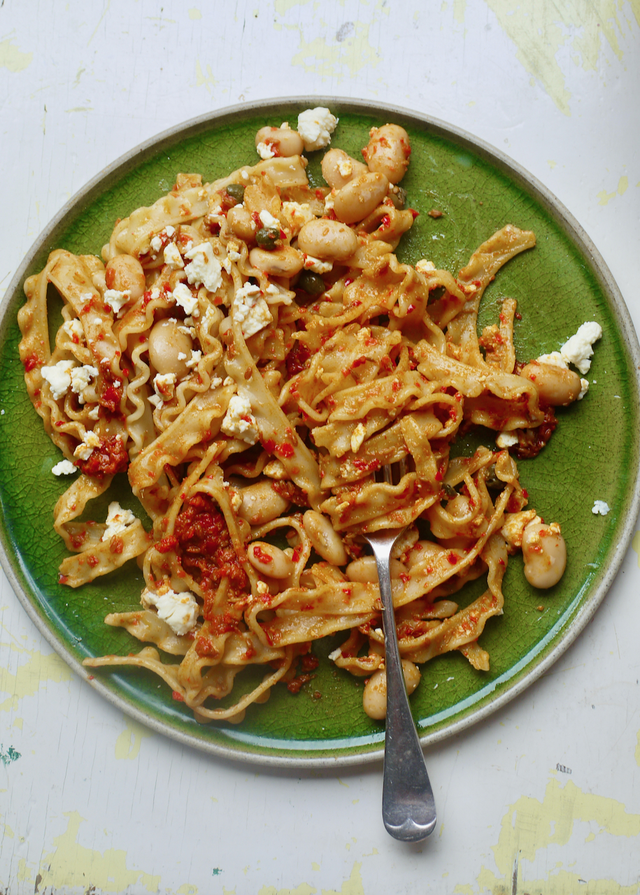 A green plate with pasta on it