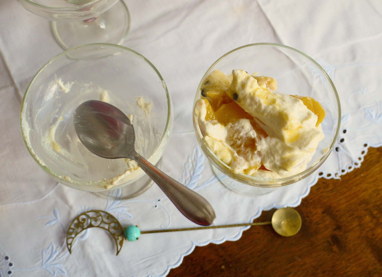 two coupe glasses, one with trifle and one with a teaspoon