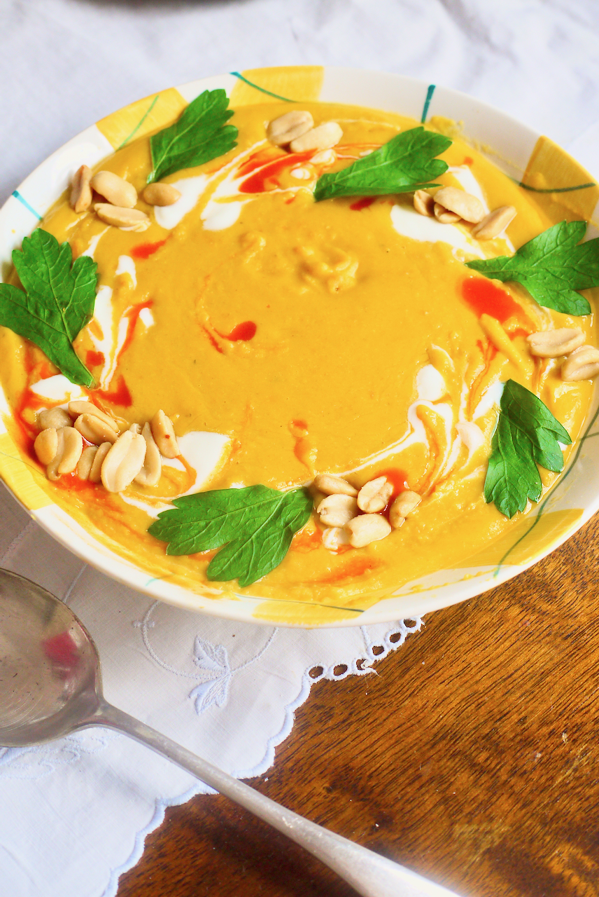 butternut soup with a soup spoon on a white tablecloth