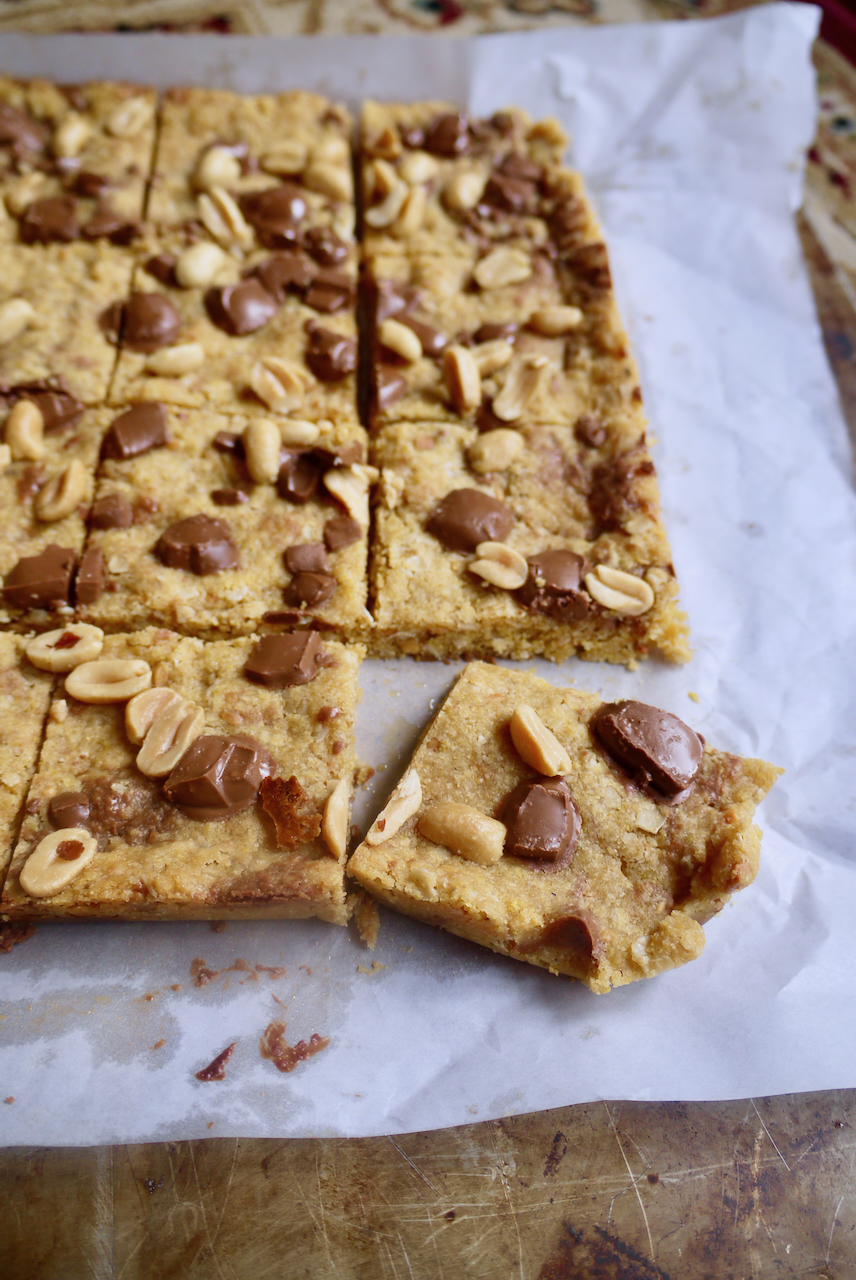 Slices of peanut butter chocolate chunk squares on a sheet of baking paper