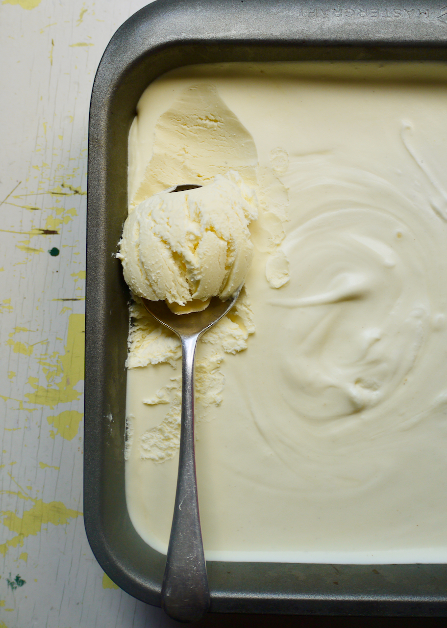 A spoonful of icecream resting on top of a dish of ice cream