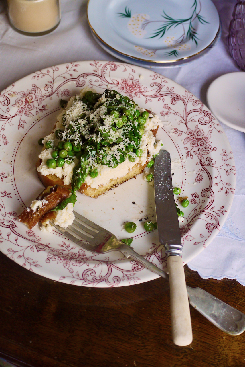 A knife and fork resting on a white and pink plate, with a slice of toast cut into
