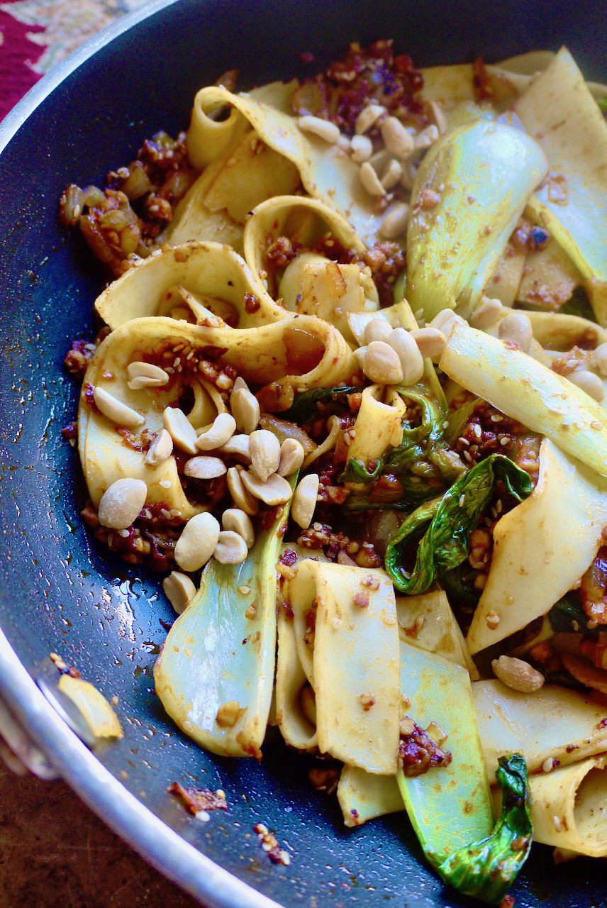 A pan of noodles, vegetables and peanuts