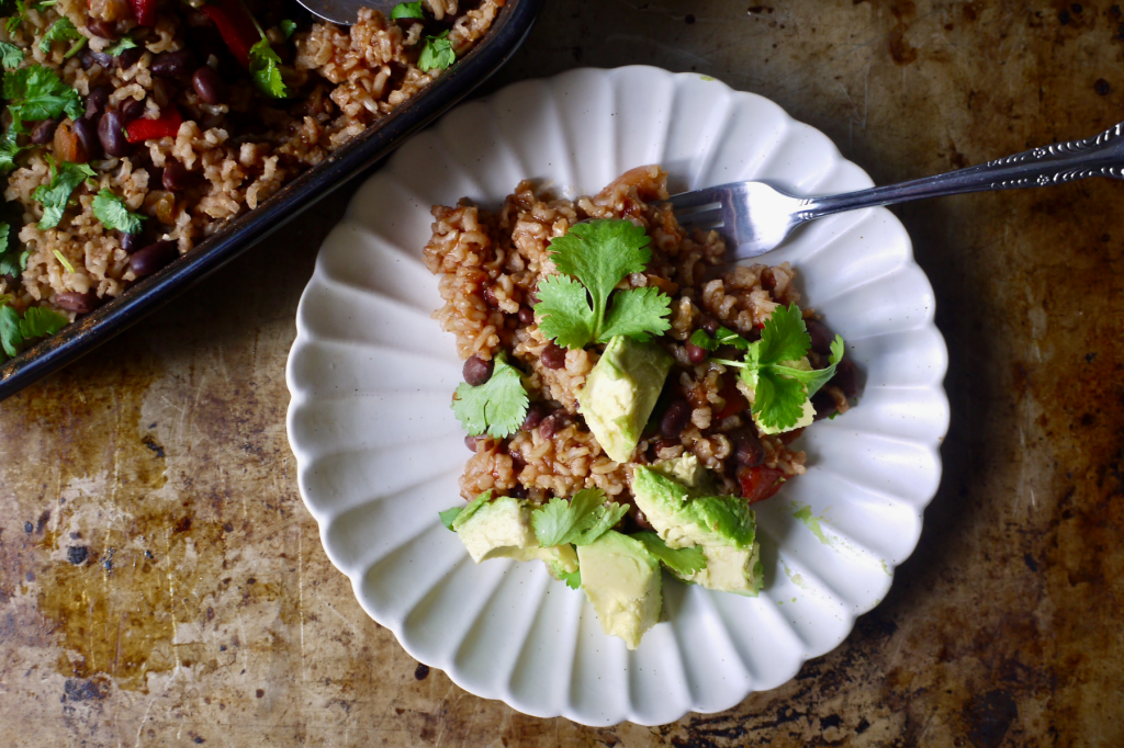 A white fluted plate of black bean and brown rice casserole. This image links to a web page with this recipe.