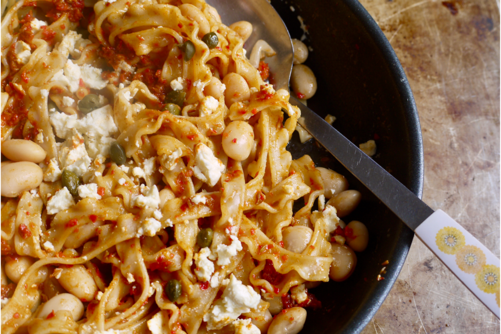 A saucepan of pasta and beans with a serving spoon. This image links to a web page with this recipe.