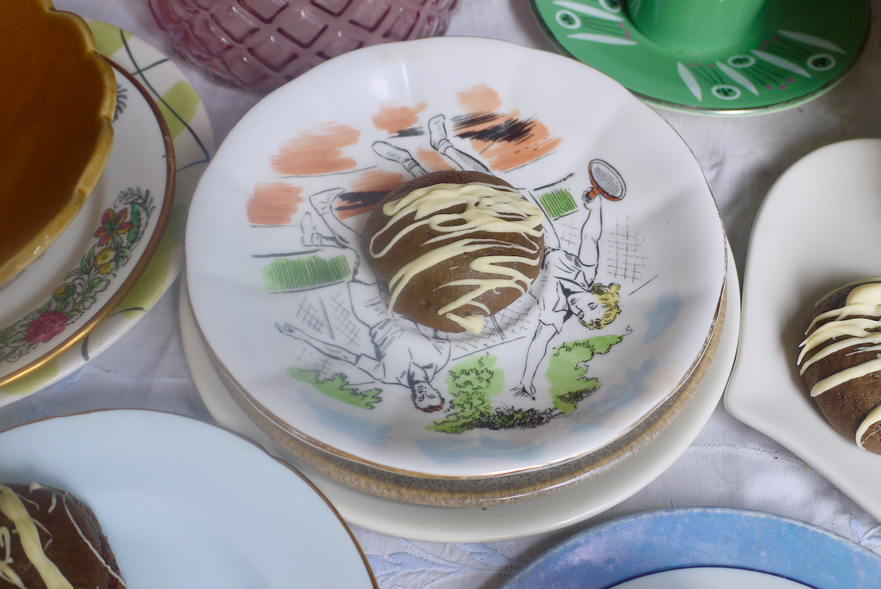A molasses cookie on a small white plate surrounded by other small plates
