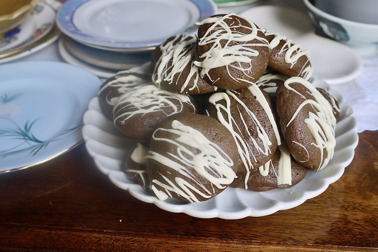 Molasses cookies, piled up on a white fluted plate