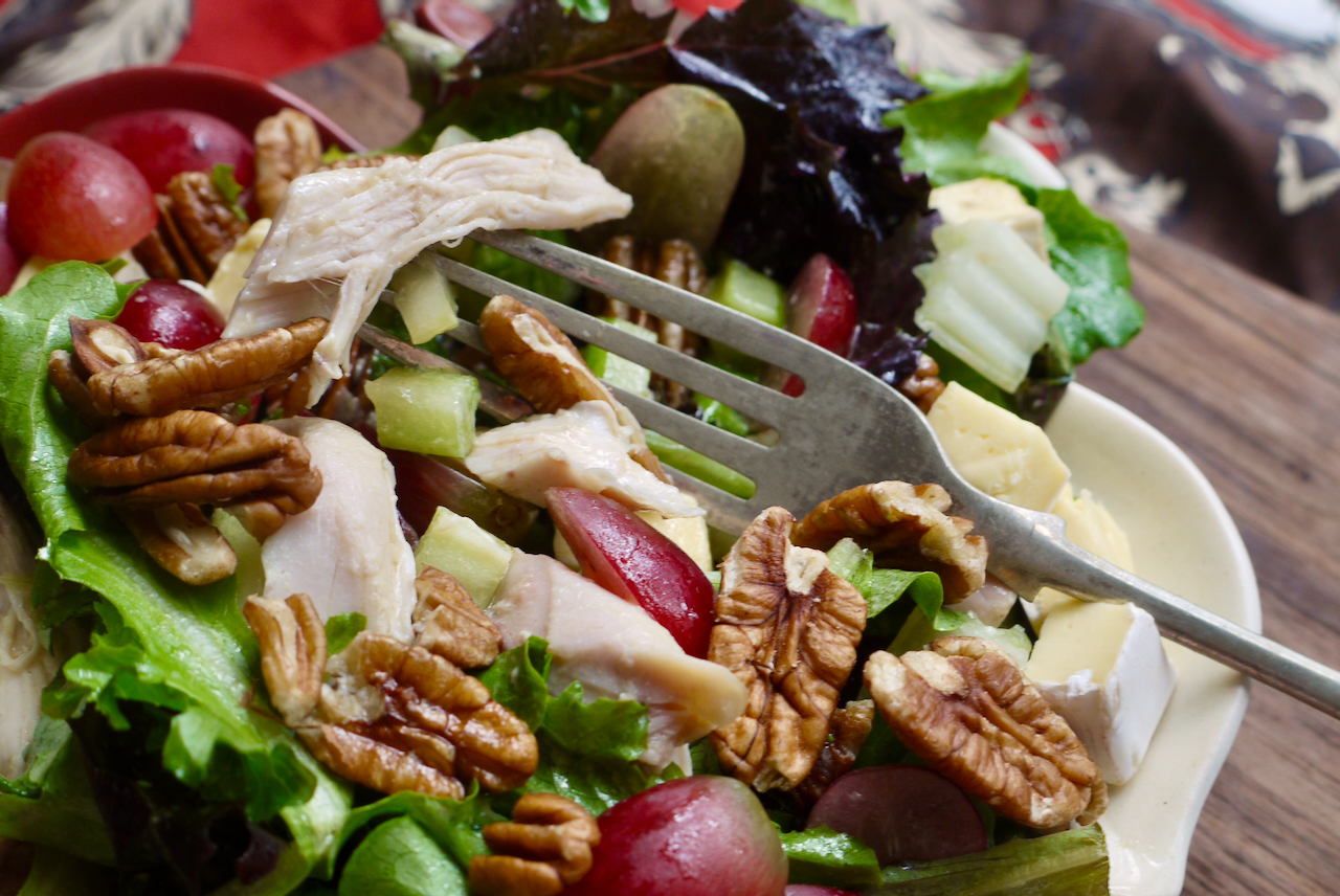 A fork resting on a plate of salad