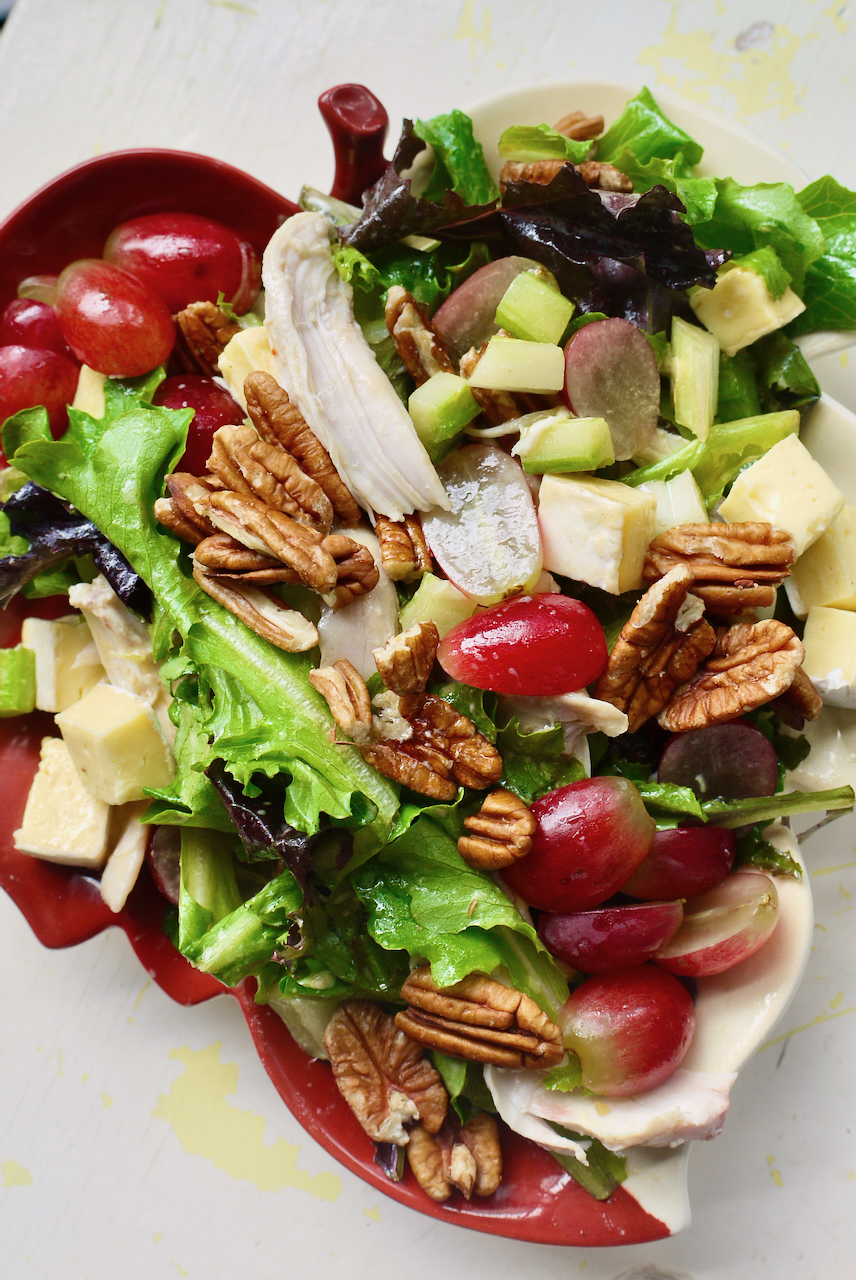 A leaf-shaped plate of salad on a white background