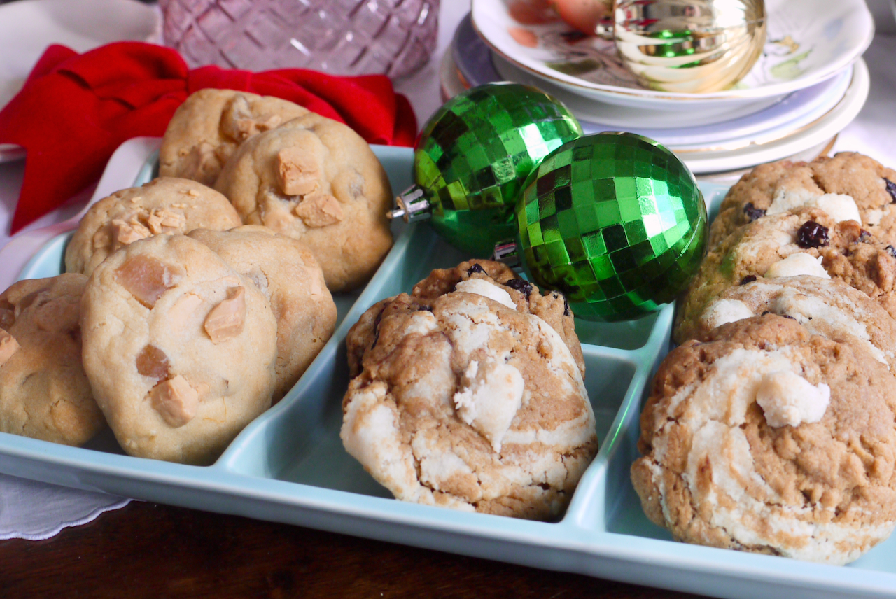 Cookies arranged on a mint green dish with green baubles and gold baubles in the background