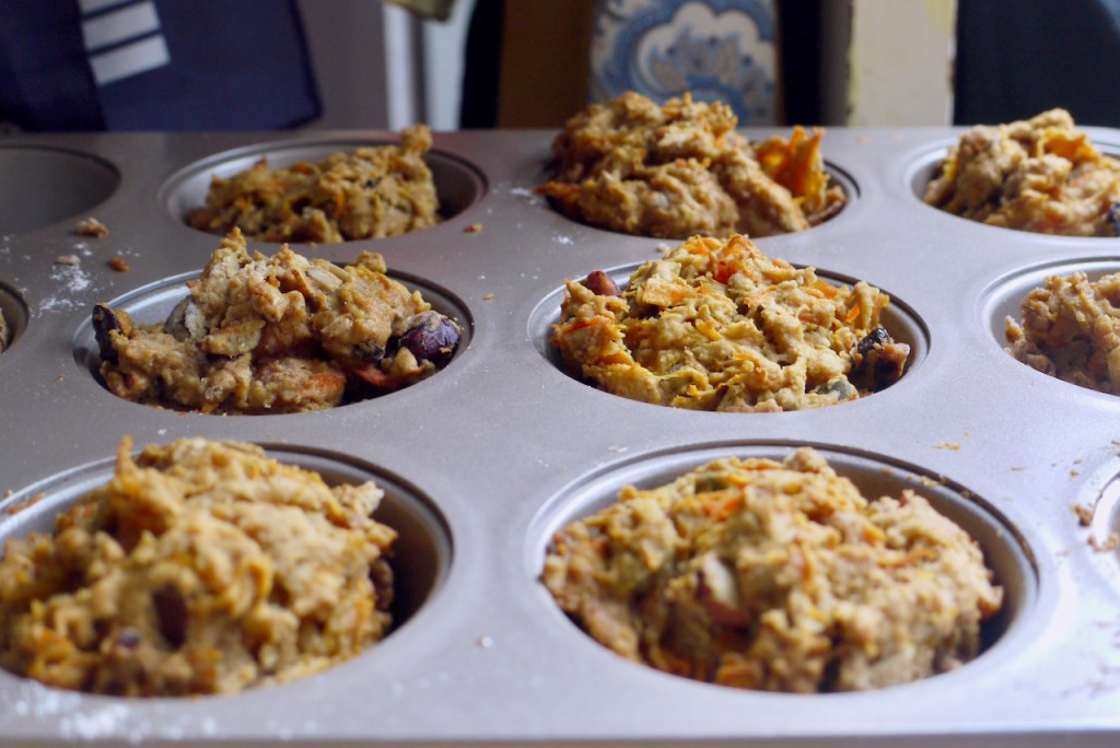 A close up of carrot granola muffins still in their tin