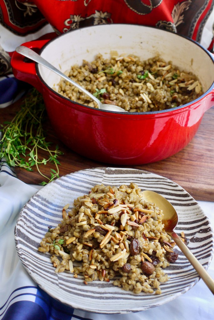 A striped plate of pilaf in front of a red casserole dish