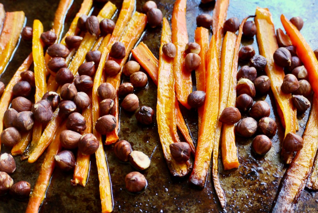 Roasted carrots and hazelnuts on an oven tray