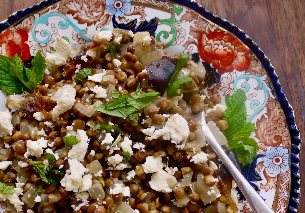 A forkful of lentil salad on a red and blue plate