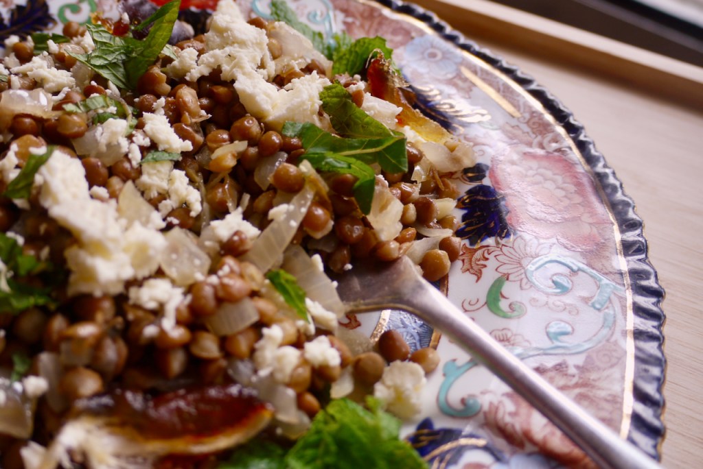 A forkful of lentil salad with chopped mint leaves