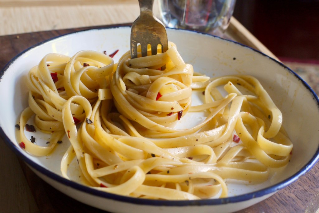 A fork twirling pasta on a white plate