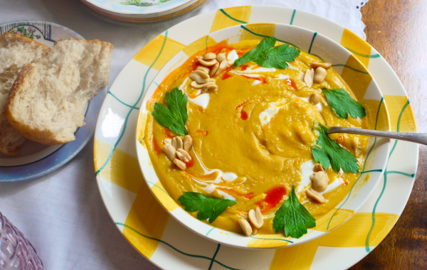 A yellow and white bowl of soup with parsley garnishing and bread on the side. This image links to the recipe.