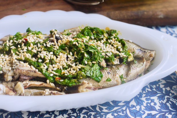 Close up of sardines garnished with chopped mint